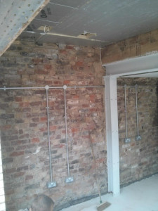 All the wiring is in galvanised steel conduit. The exposed bricks will be protected by external wall insulation on the outside.